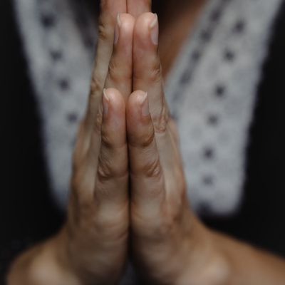 Close-up on hands in a meditative mudra position.