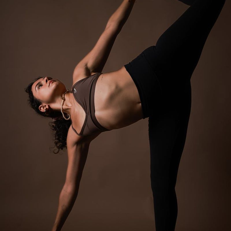Woman holding a strong yoga pose, demonstrating balance and focus.